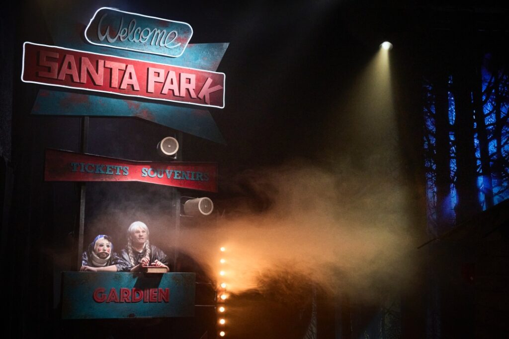 Deux enfants tiennent la caisse d'entrée au Santa Park dans une atmosphère lugubre.